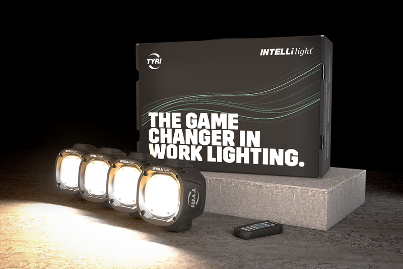 4 illuminated LED work lights sit next to each other in front of the INTELLilight starter kit box with the small remote control in the right hand bottom corner.