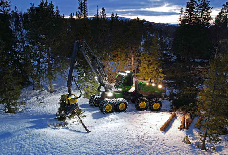 A large forestry machine at work at dusk using their TYRI work lights.