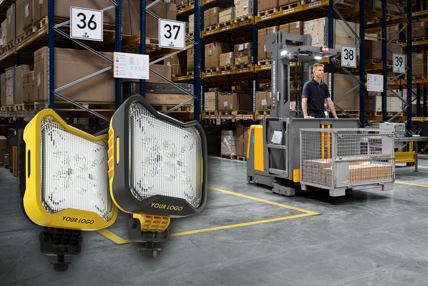 A background image of a material handling machine and operator moving through a warehouse with 2 square LED work lights in yellow and black overlaid in the left-hand corner.